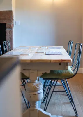 a wooden table with chairs in a room at Gatesgarth Cottage @ The Pheasant Inn in Brampton