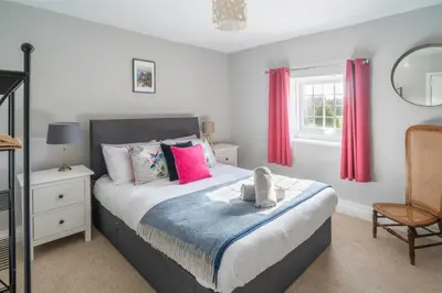 a bedroom with a bed with red curtains at Gatesgarth Cottage @ The Pheasant Inn in Brampton
