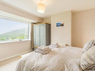 a bedroom with a white bed with a large window at Fairview in Keswick
