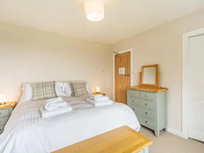 a bedroom with a bed and a dresser and a mirror at Fairview in Keswick