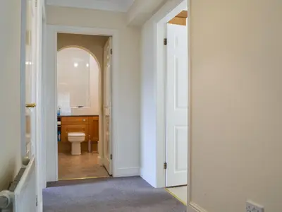 a hallway with a bathroom with a toilet and a mirror at Six The Hollies in Keswick