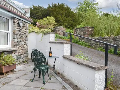 a table and a chair sitting on a patio at Six The Hollies in Keswick