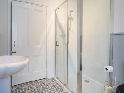 a white bathroom with a sink and a shower at Yewthwaite Newlands Keswick in Keswick
