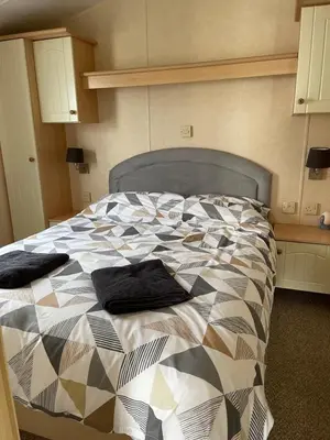 a bedroom with a bed with a quilt on it at Beautiful 2-Bed Static caravan in Newton Stewart