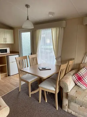 a dining room table and chairs in a kitchen at Beautiful 2-Bed Static caravan in Newton Stewart