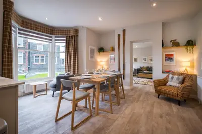 a dining room and living room with a table and chairs at Howe Keld 5 First Floor in Keswick