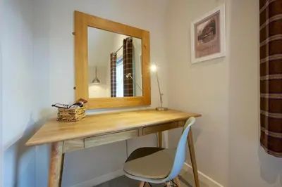 a dressing table with a mirror and a chair at Howe Keld 5 First Floor in Keswick