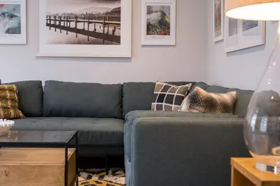 a living room with a blue couch and a table at Howe Keld 5 First Floor in Keswick