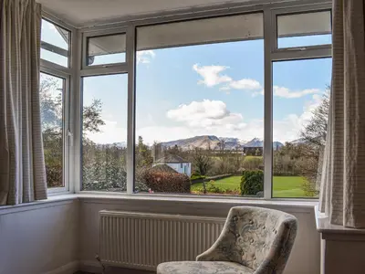 a chair sitting in front of a large window at Littlethwaite in Keswick