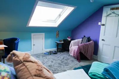 a living room with a skylight and blue walls at The Art Bank in Dalbeattie