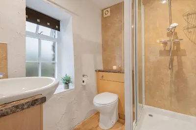 a bathroom with a toilet and a sink and a shower at Cottage 2, Old Farmhouse Mews in Braithwaite