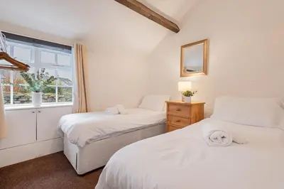 a bedroom with two beds and a window at Cottage 2, Old Farmhouse Mews in Braithwaite