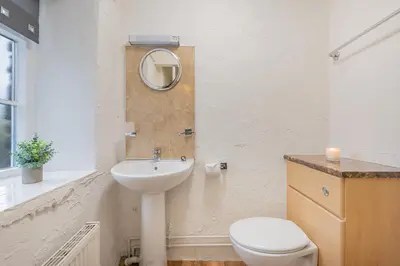 a bathroom with a sink and a toilet and a mirror at Cottage 2, Old Farmhouse Mews in Braithwaite