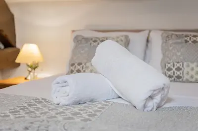 a stack of white towels on a bed at Cottage 2, Old Farmhouse Mews in Braithwaite