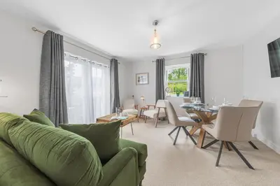a living room with a green couch and a table at Derwent Cottage in Keswick
