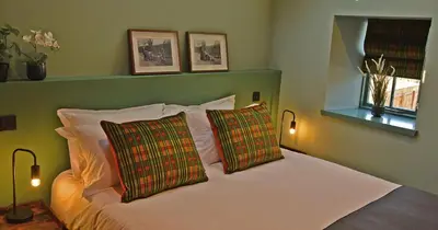 a bedroom with a white bed with two pillows at Masonic Arms Gatehouse in Gatehouse of Fleet