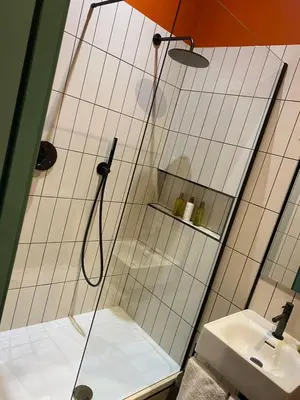 a shower with an orange umbrella in a bathroom at Masonic Arms Gatehouse in Gatehouse of Fleet
