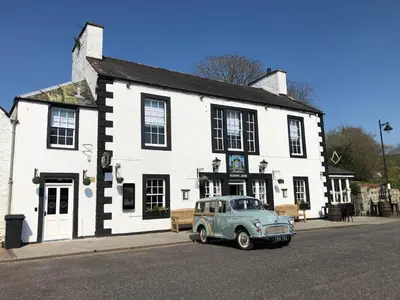 an old car parked in front of a white building at Masonic Arms Gatehouse in Gatehouse of Fleet