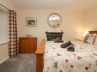 a bedroom with a bed and a mirror at Nook Cottage in Keswick