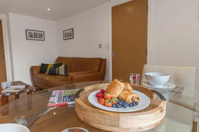 a plate of food on a table in a living room at Chaucer's Retreat, Chaucer House, Keswick in Keswick