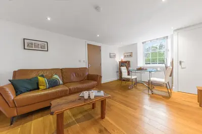 a living room with a couch and a table at Chaucer's Retreat, Chaucer House, Keswick in Keswick