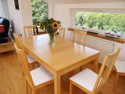 a dining room table with chairs and a vase of flowers at Annapurna in Portpatrick