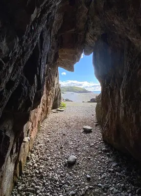 a cave with a view of the ocean through it at Islecroft House Bed & Breakfast in Isle of Whithorn