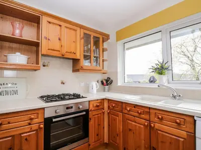 a kitchen with wooden cabinets and a stove top oven at Noble Knott in Keswick