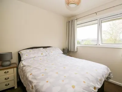 a white bedroom with a bed and a window at Noble Knott in Keswick