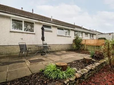 a patio with a table and chairs in front of a house at Noble Knott in Keswick
