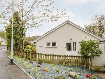 a white house with a fence and flowers at Noble Knott in Keswick