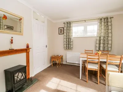 a dining room with a table and a fireplace at Noble Knott in Keswick