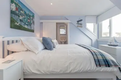 a bedroom with blue walls and a white bed at Carlton House Portpatrick in Portpatrick