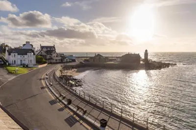 a view of a town with a lighthouse and the ocean at Carlton House Portpatrick in Portpatrick