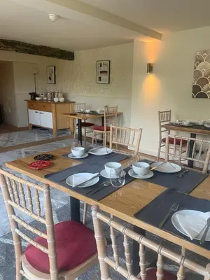 a wooden table with plates and bowls on top of it at Fiddleback Farm in Wigton