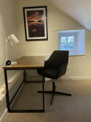 a desk with a chair in a room with a window at Brandlehow HOT TUB HIRE AVAILABLE in Portinscale