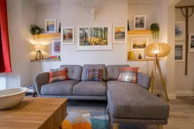 a living room with a couch and a table at Howe Keld 1 Ground floor in Keswick