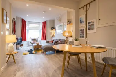a living room with a table and a couch at Howe Keld 1 Ground floor in Keswick