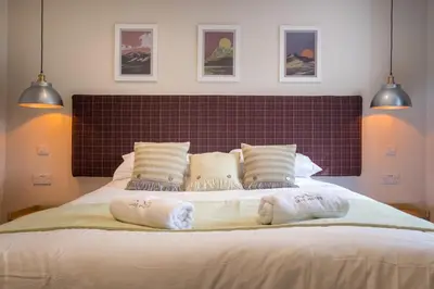 a bedroom with a large bed with two towels on it at Howe Keld 1 Ground floor in Keswick