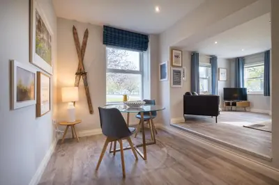 a living room with a glass table and chairs at Howe Keld 3 Ground floor in Keswick