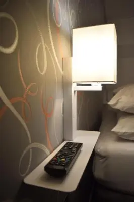 a remote control sitting on a table next to a lamp at The Dwelling Place in Irvine