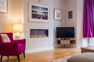 a living room with a tv and a fire place at Howe Keld 2 Ground Floor in Keswick