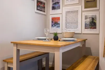 a dining room table with two wine glasses on it at Howe Keld 2 Ground Floor in Keswick