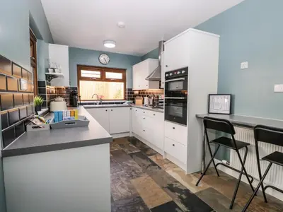 a kitchen with white cabinets and black appliances at No 2 Waterloo Street in Cockermouth