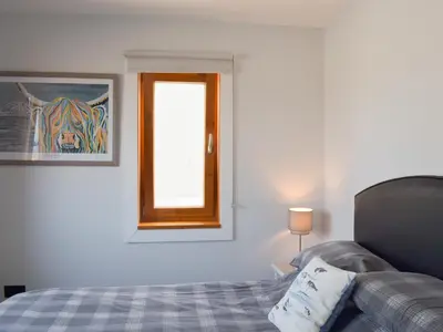 a bedroom with a bed with a mirror and a window at Seal Rocks in Lendalfoot