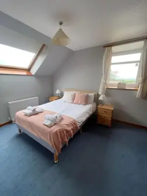 a bedroom with a bed with two towels on it at AIRDSIDE COTTAGE in Castle Douglas