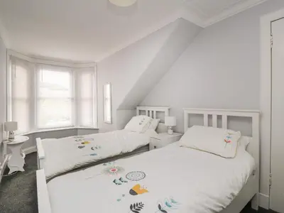 two beds in a bedroom with white walls at Willowbank in Ayr
