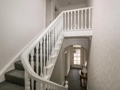 a staircase with white railings in a home at Willowbank in Ayr