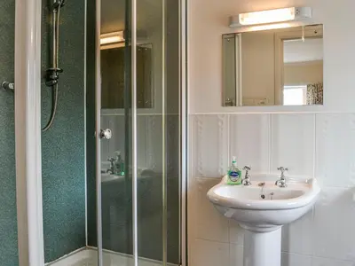 a bathroom with a sink and a shower and a sink at Auld Dairy Cottage in Drummore