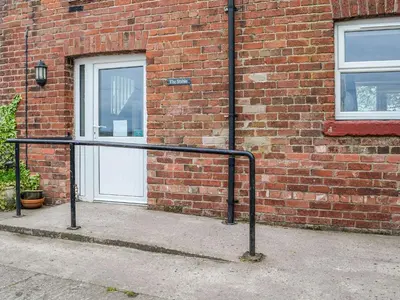 a metal rail in front of a brick building at Mount Farm - The Stable in Harker